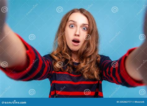 woman taking selfie with shocked facial expression looking with big eyes and open mouth pov