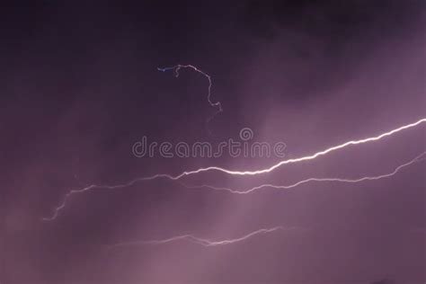 Lightning Discharges In Stormy Sky Under Dark Rain Clouds At Night