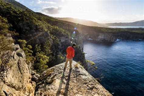 Image Of A Man Stands On A Cliff Overlooking The Ocean Austockphoto