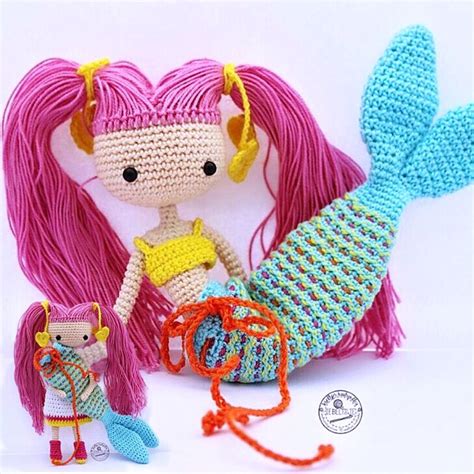 A Crocheted Doll With Pink Hair Next To A Knitted Mermaid Tail And Purse