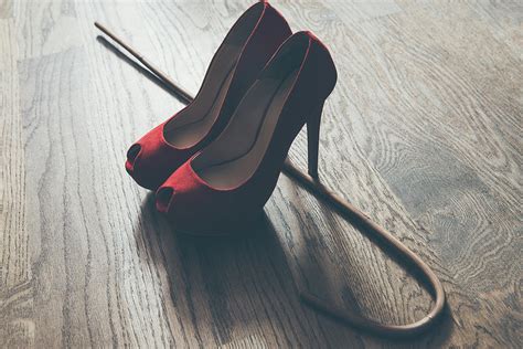 Woman Red High Heel Shoes And Rattan School Cane Strict Domination