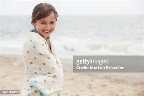 caucasian girl wrapped in towel on beach photo getty images