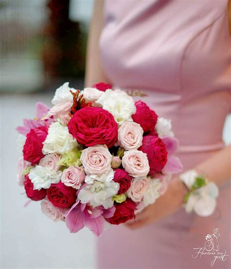 A Woman In A Pink Dress Holding A Red And White Bouquet