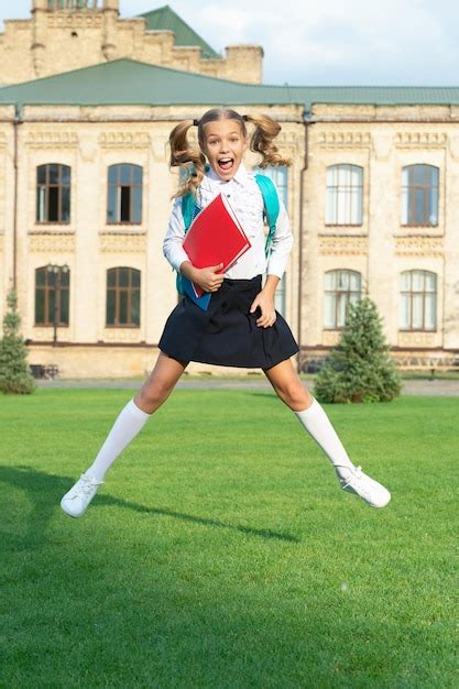 Возбужденная девочка подросток в школьной форме прыгает в воздухе энергичная девочка подросток