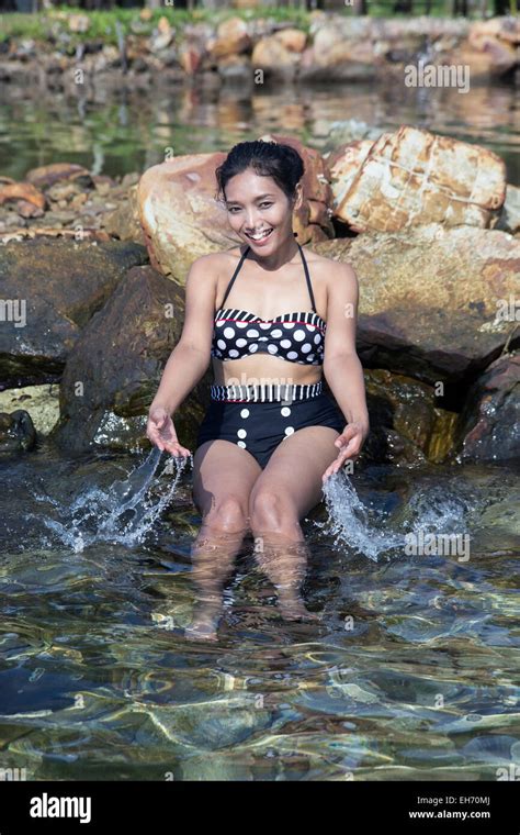 Cheerful Woman Squirting Water On The Coast Stock Photo Alamy
