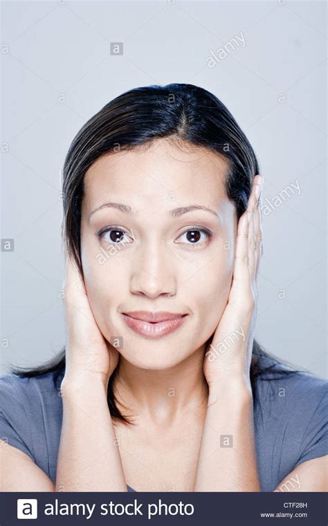 Portrait Of Young Woman With Hands Covering Ears Studio Shot Stock