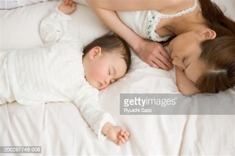 Mother And Daughter Sleeping Side By Side Elevated View High Res Stock