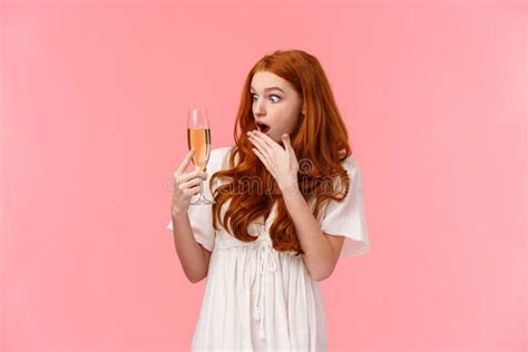 shocked and astounded redhead woman surprised as cant remember when she took glass with