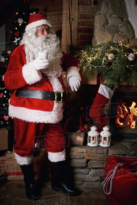 Santa Claus Standing Beside Fireplace Holding Glass Of Milk Stock