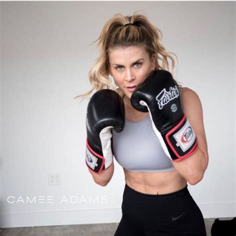 A Woman Wearing Black Boxing Gloves Posing For A Photo With Her Hands On Her Hips