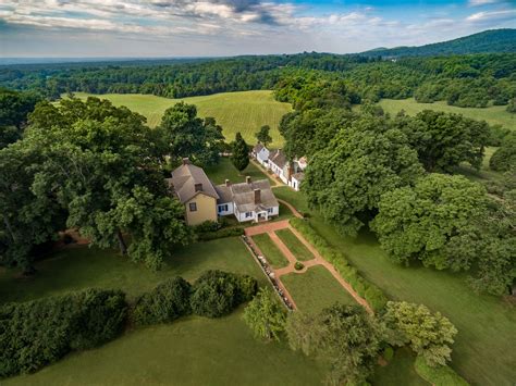 An Aerial View Of A Large Home Surrounded By Trees And Grass In The