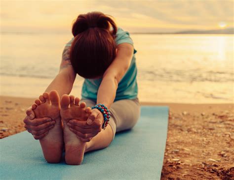 Woman Doing Yoga Exercise On Beach