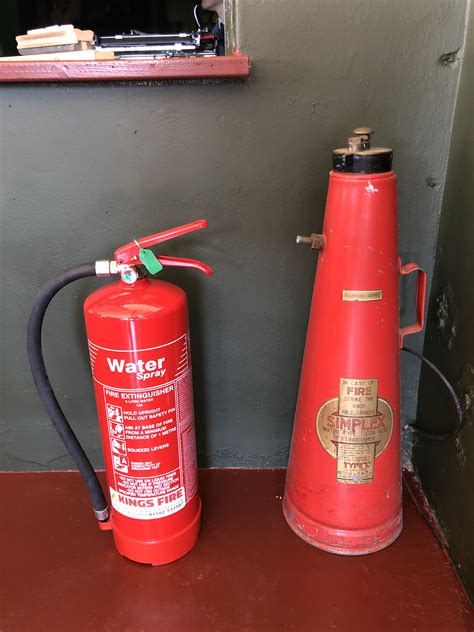 Vintage Extinguisher Next To Modern Water Extinguisher Fire