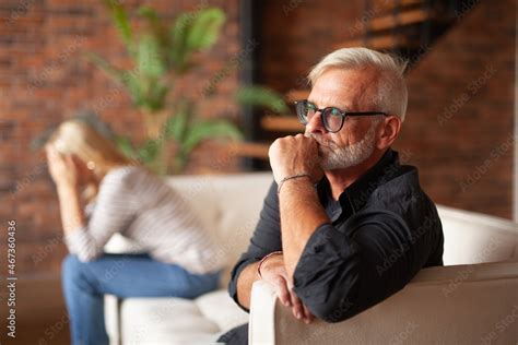 Upset Mature Husband Is Sitting On The Couch With His Wife Divorce Of An Older Couple Crisis