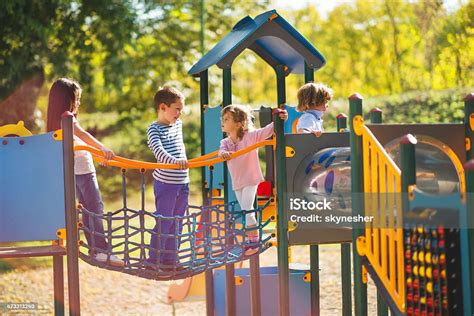 Children Playing In The Park At Playground And Communicating Stock