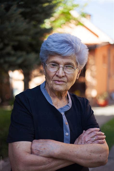 Portrait Of An Old Woman With Glasses An White Hair Looking At Camera By Stocksy Contributor