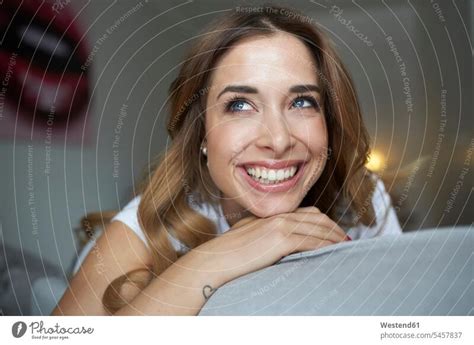 porträt einer glücklichen jungen frau auf der couch ein lizenzfreies stock foto von photocase