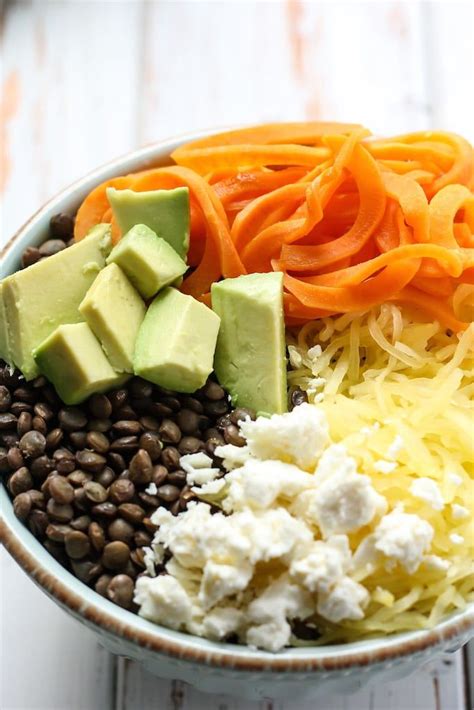 A Bowl Filled With Beans Carrots Avocado And Other Food Items