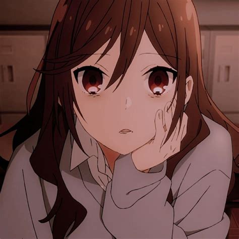 An Anime Girl With Long Brown Hair And Orange Eyes Sitting In Front Of