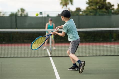 Boy Focused With Good Form Playing Tennis With Mom On Holiday Porjp Danko
