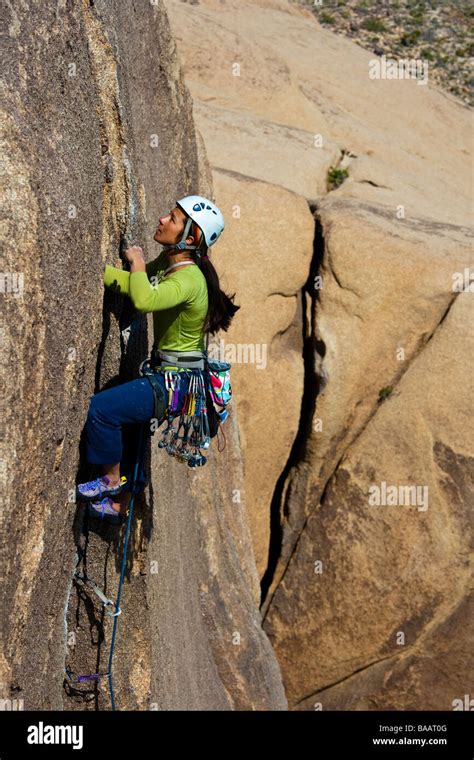 Female Rock Climber Clings To The Side Of Cliff Stock Photo Alamy