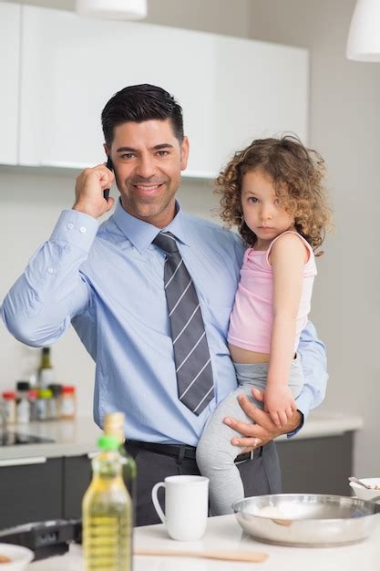 Premium Photo Well Dressed Father Carrying Daughter While On Call