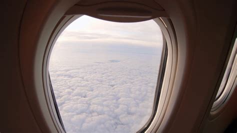 Airplane Window View Of A Flight Above Clouds By Sunrise Stock Video
