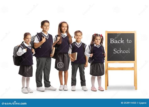 Schoolchildren Standing Next To A Small Blackboard With Message Back To