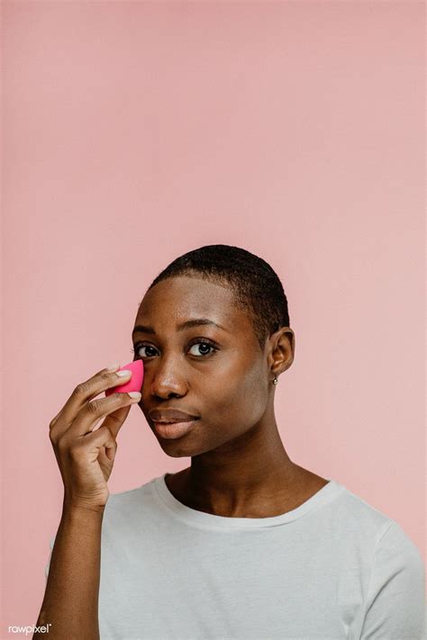 download premium image of cheerful black beauty blogger using a pink makeup blending sponge by