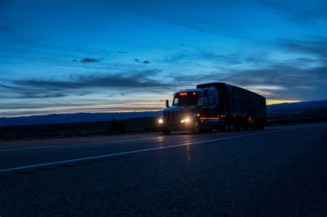 A Semi Trailer Truck Driving Down The Highway In Colorado At Night