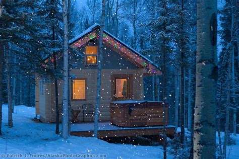 Snow Falling Around A Log Cabin Tucked In The Boreal Forest In