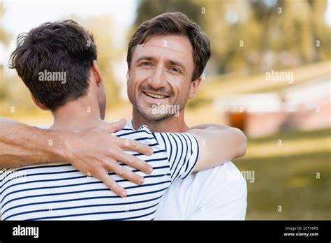 Back View Of Teenager Son Hugging Joyful Father Outside Stock Photo Alamy