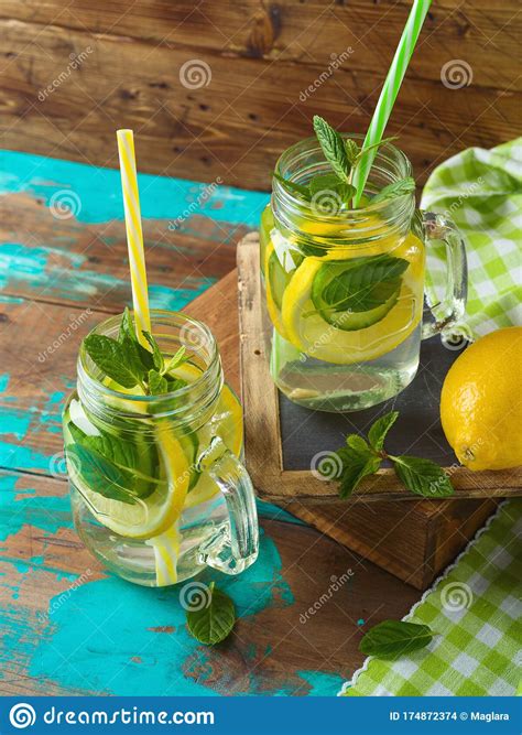 Infused Water With Lemon Cucumber And Mint Leaves Over Wooden