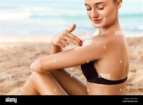 Sun Cream Skin And Body Care Woman In Bikini Applying Sunscreen Solar On Tanned Shoulder Sun