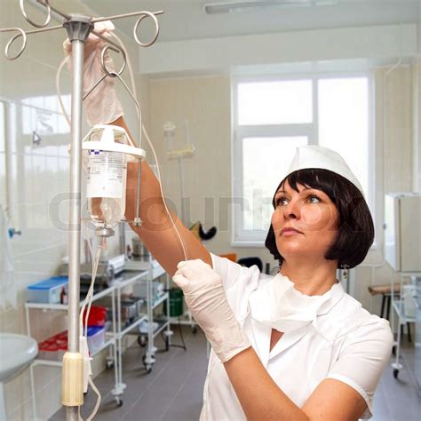 beautiful nurse preparing to hold intravenous drip medication stock image colourbox