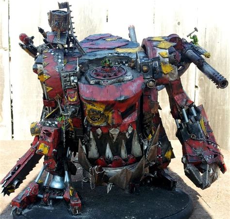 A Red And Yellow Painted Robot Like Vehicle On A Black Base With Metal