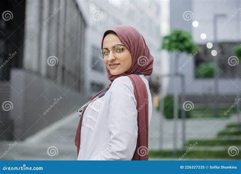 Smiling Confident Muslim Female Nurse Or Doctor Wearing Hijab Posing At Camera Outdoors Stock