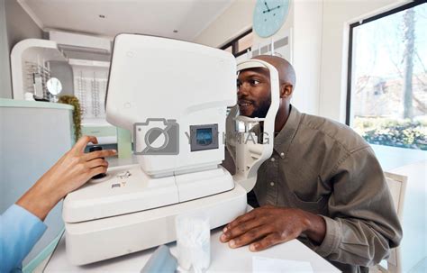 Eye Test Exam Or Screening With A Young Man At The Optometrist Using