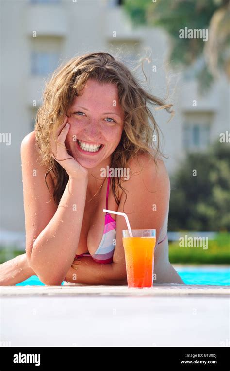 Mujer Sonriente En La Piscina Con Un Cóctel Fotografía De Stock Alamy