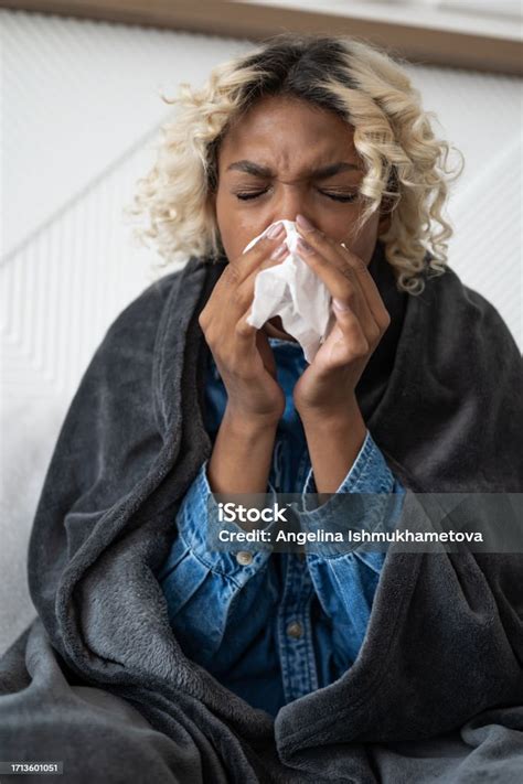 Closeup Of Sick Young Black Woman Sitting Under The Blanket On Sofa And