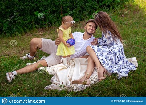 Familia Feliz Divirtiéndose En El Parque Padres Con Hija Relajándose Al Aire Libre Imagen de