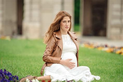 Mujer Embarazada Hermosa Que Se Sienta En El Parque En El Banco Foto De