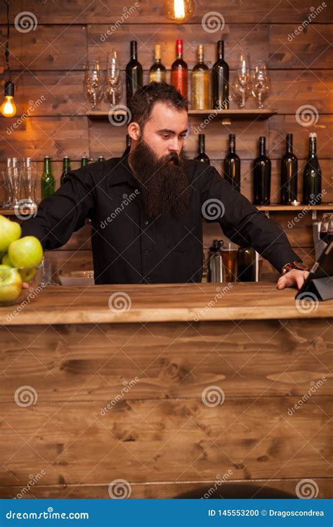 Bearded Handsome Young Bartender Behind The Bar Counter Stock Photo