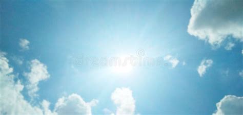 The Sun Brightly Shining In The Cloudy Blue Sky Stock Photo Image Of