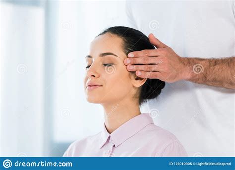 view of masseur putting hands on temples of woman with closed eyes stock image image of girl