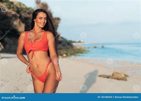 Portrait Of Beautiful Girl In Red Swimwear With Long Hair Posing On Beach With White Sand Stock