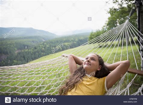 Serene Girl Laying In Rural Hammock Looking Up With Hands Behind Head