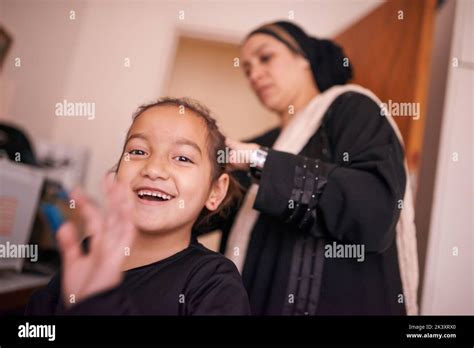 Passing on traditions. a mother helping her daughter put on a headscarf