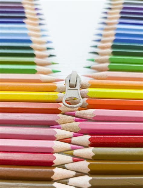 Closeup Of Colored Pencils Lined Up In A Row And Abstract Shape On