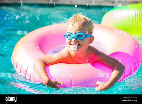 Little Kid Having Fun In Swimming Pool With Goggles And Raft Summer
